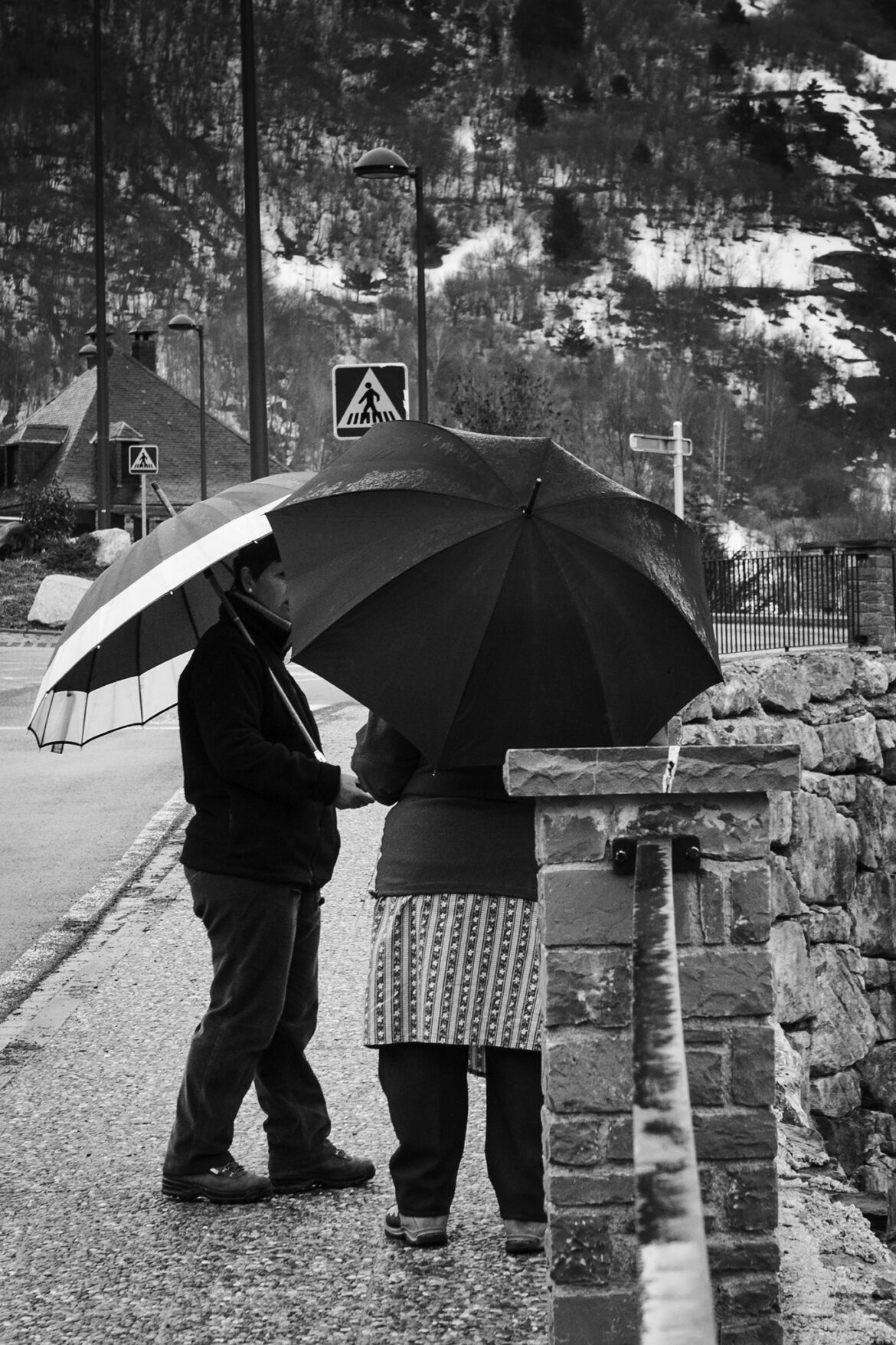 Fotografia de dos personas, con un paraguas pueblo de Vilac - Val d'aran